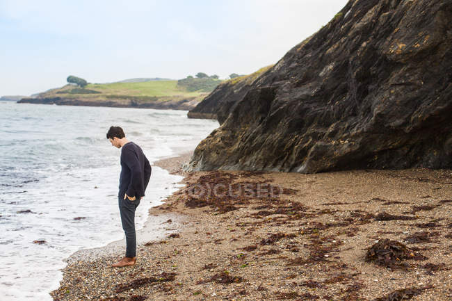 Чоловік стоїть на морському березі — стокове фото