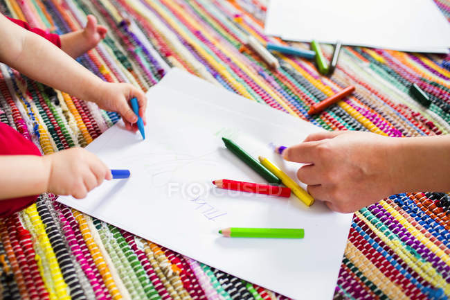 Мать с дочерью рисуют на бумаге — стоковое фото