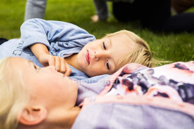 Niño con hermana relajándose en el patio - foto de stock