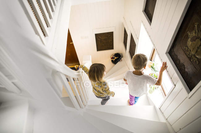 Brother and sister walking down stairs — Stock Photo