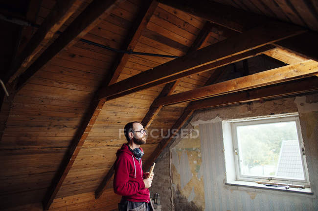 Uomo che ispeziona soffitta — Foto stock