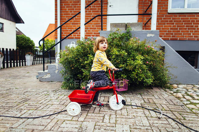 Girl riding tricycle — Stock Photo