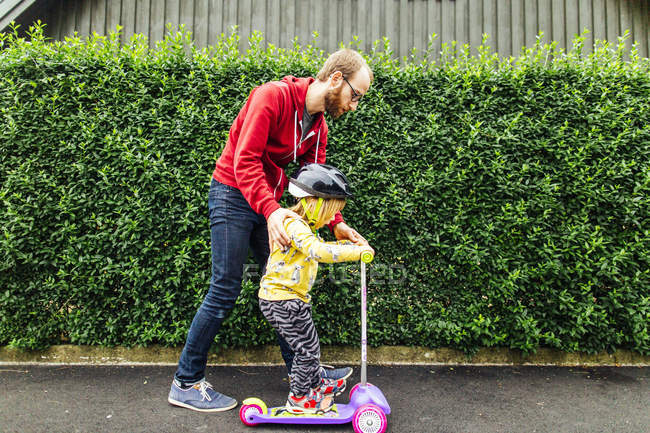 Мужчина учит дочь ездить верхом — стоковое фото