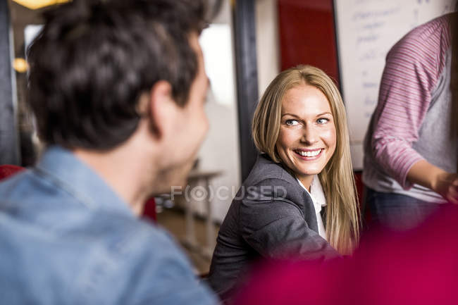 Бізнес-леді обговорює з колегою в офісі — стокове фото