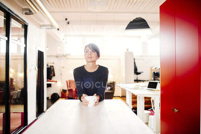 Задуманная деловая женщина с кофейной кружкой — стоковое фото