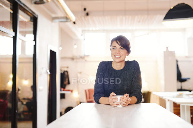 Mujer de negocios sonriente mirando hacia otro lado - foto de stock