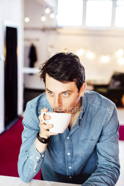 Вдумчивый бизнесмен пьет кофе — стоковое фото