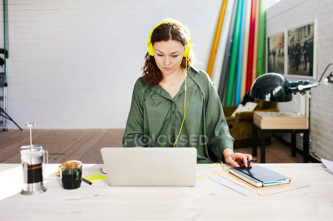 Mulher de negócios adulta média usando fones de ouvido — Fotografia de Stock