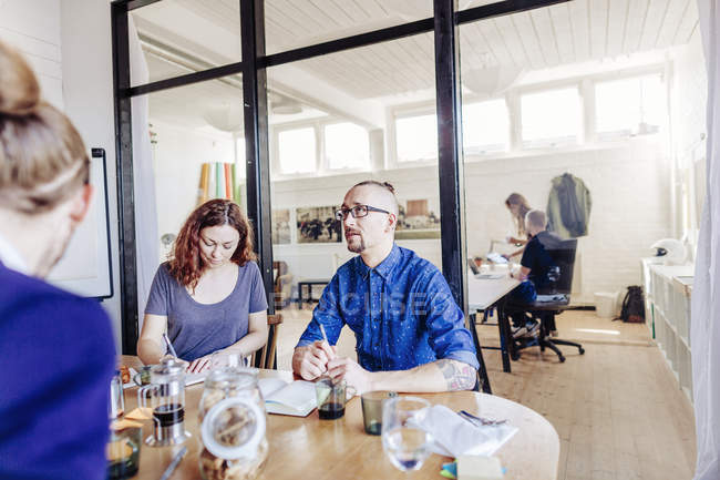 Businessman with colleagues working at table — Stock Photo