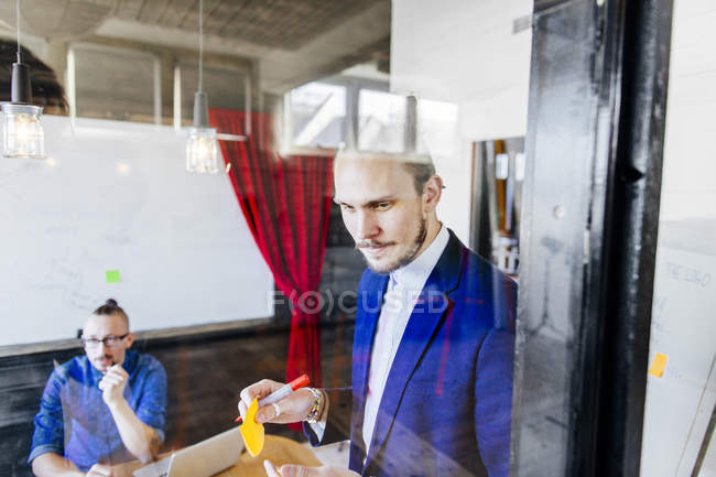 Pensativo hombre de negocios con pluma - foto de stock