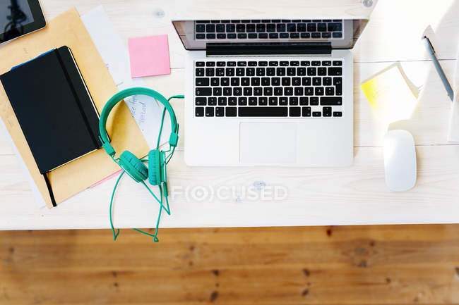 Laptop e fones de ouvido na mesa — Fotografia de Stock