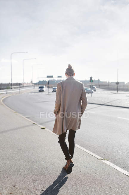 Jeune homme marchant sur le trottoir — Photo de stock