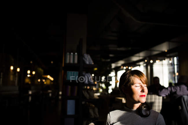 Mujer sentada en la cafetería - foto de stock