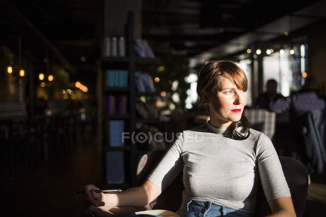 Donna seduta alla caffetteria — Foto stock