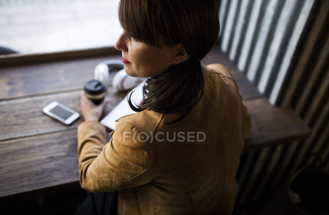 Woman sitting at table in cafe — Stock Photo