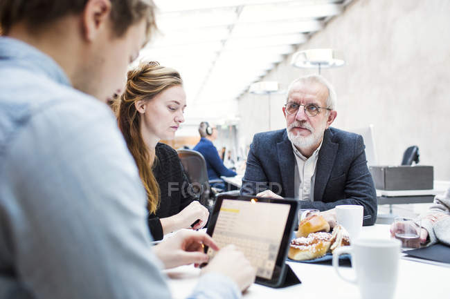 Бізнесмен дивиться на колегу за допомогою планшета — стокове фото