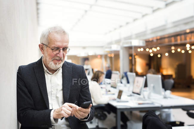 Homme d'affaires senior utilisant le téléphone mobile — Photo de stock