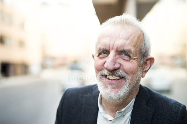 Senior businessman smiling outdoors — Stock Photo