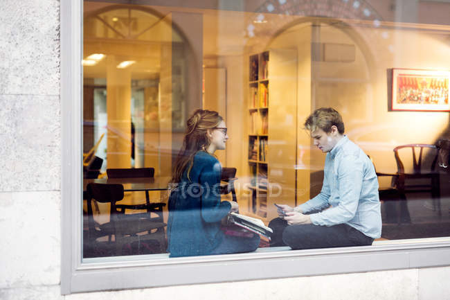 Uomo d'affari e donna d'affari visti attraverso la finestra — Foto stock