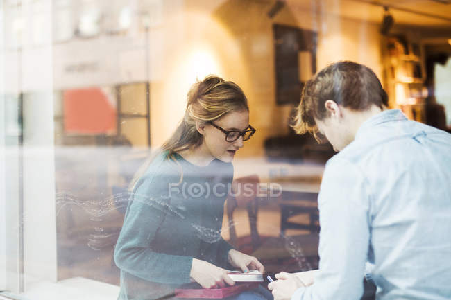 Бизнесмен и деловая женщина обсуждают через окно офиса — стоковое фото
