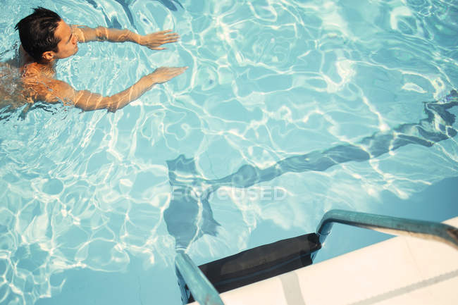 Hombre joven nadando en la piscina - foto de stock
