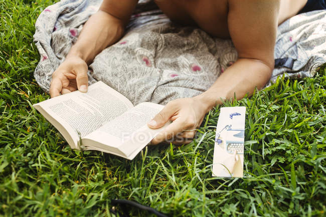 Чоловік читає на трав'янистому полі — стокове фото