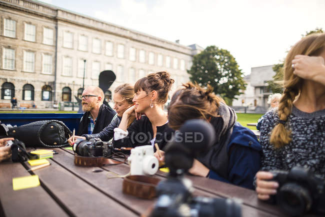 Amigos sentados a la mesa en el parque - foto de stock