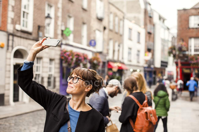 Усміхається жінка, беручи selfie — стокове фото