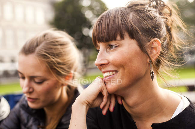 Woman sitting with female friend — Stock Photo