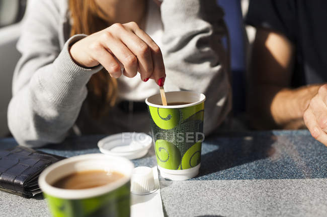 Geschäftsfrau rührt Kaffee im Zug an — Stockfoto