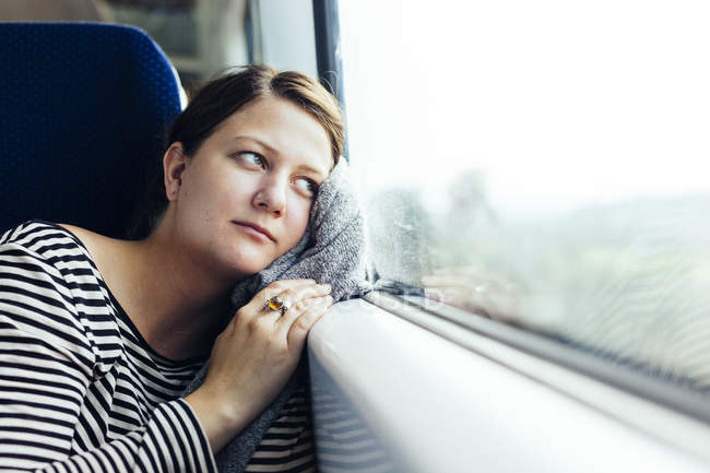 Donna d'affari guardando fuori attraverso la finestra del treno — Foto stock