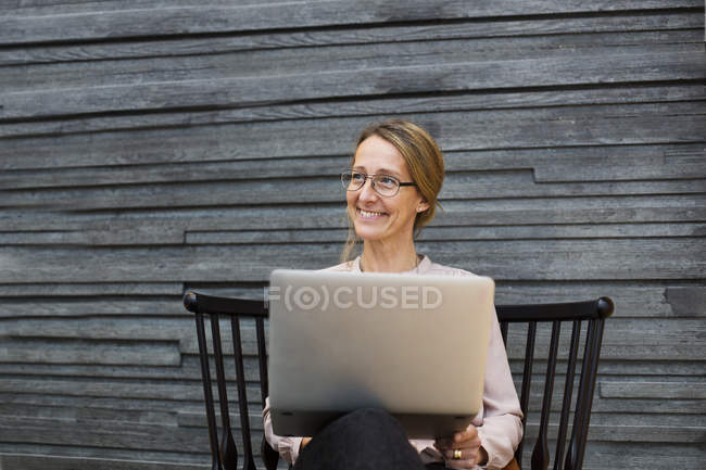 Donna d'affari felice con computer portatile — Foto stock