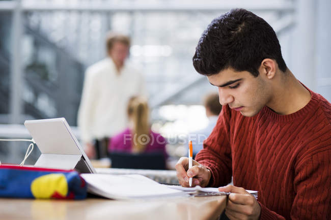 Young man writing in book — Stock Photo