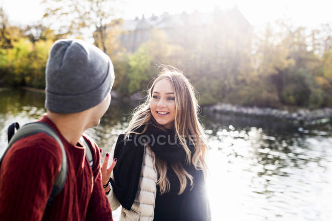 Jeune femme parlant avec un ami masculin — Photo de stock