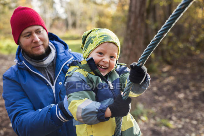 Pai assistindo menino alegre — Fotografia de Stock