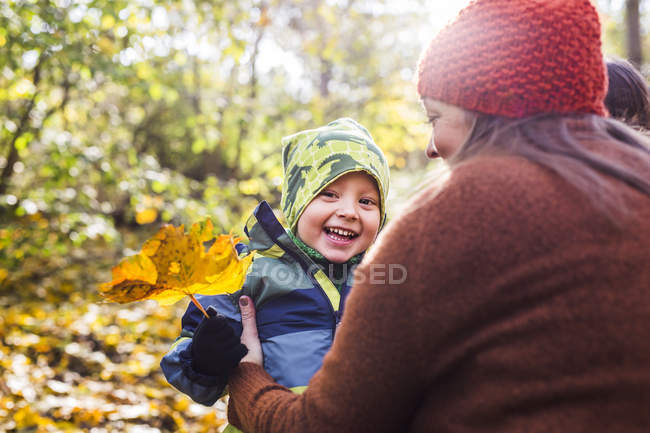 Mother with happy boy holding leaf — Stock Photo