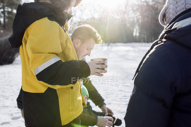 Boy having coffee while standing by family — Stock Photo