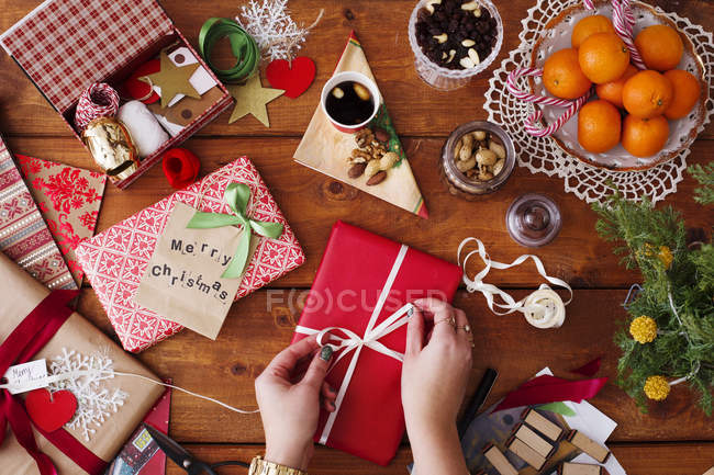 Mains attacher ruban sur cadeau de Noël — Photo de stock