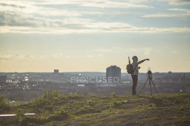 Man standing by camera on field — Stock Photo
