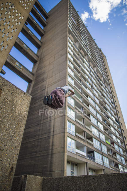 Persona che salta contro edificio — Foto stock