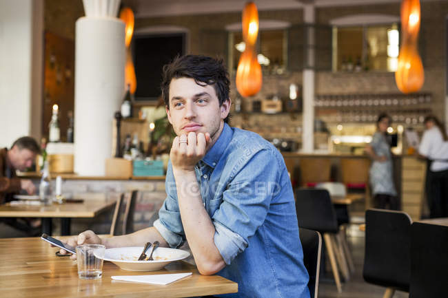 Hombre sentado en el restaurante - foto de stock