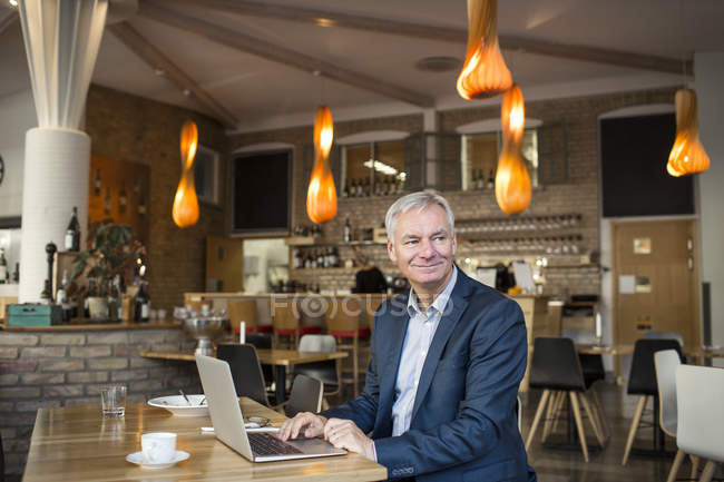 Empresário sorridente usando laptop — Fotografia de Stock