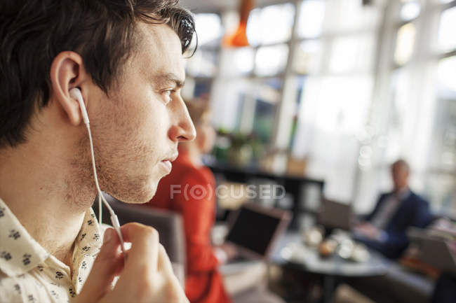 Man with earphones at restaurant — Stock Photo