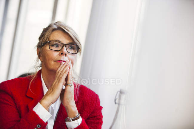 Femme d'affaires réfléchie avec les mains jointes — Photo de stock