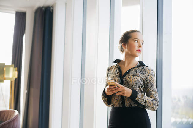 Впевнена бізнес-леді стоїть перед вікном — стокове фото