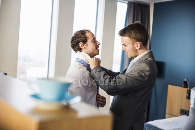 Бизнесмен завязывает галстук другу — стоковое фото