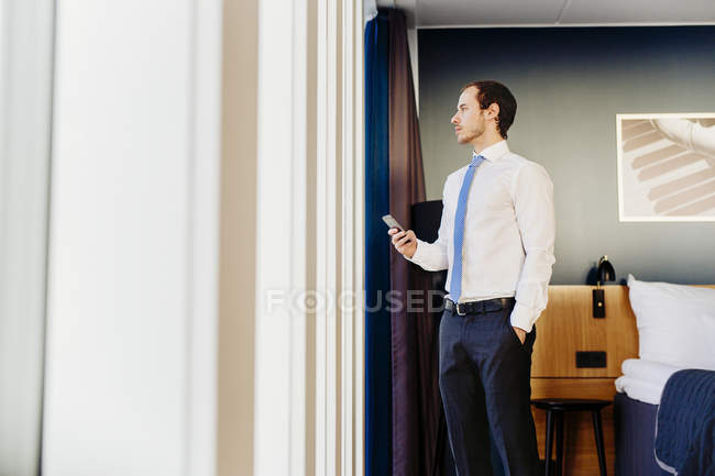 Empresário olhando pela janela — Fotografia de Stock