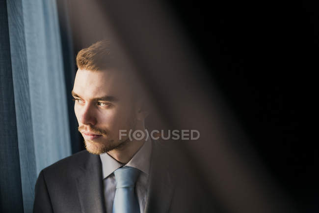 Geschäftsmann schaut durchs Fenster — Stockfoto