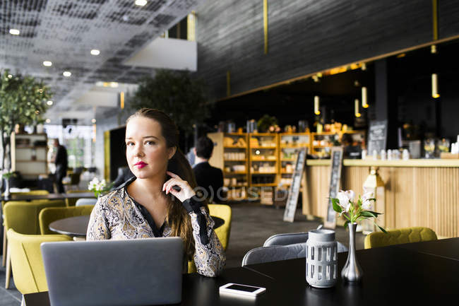 Бізнес-леді сидить за столом з ноутбуком — стокове фото