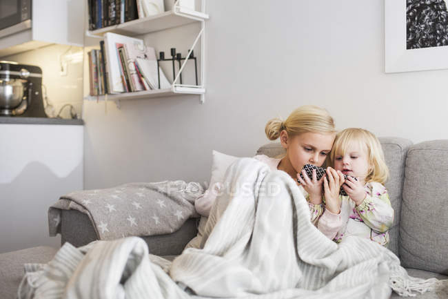 Sisters using mobile phone — Stock Photo